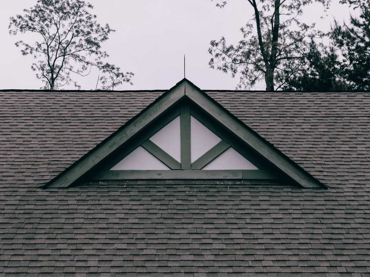 Repaired roof with matched dark architectural shingles and a clean gable